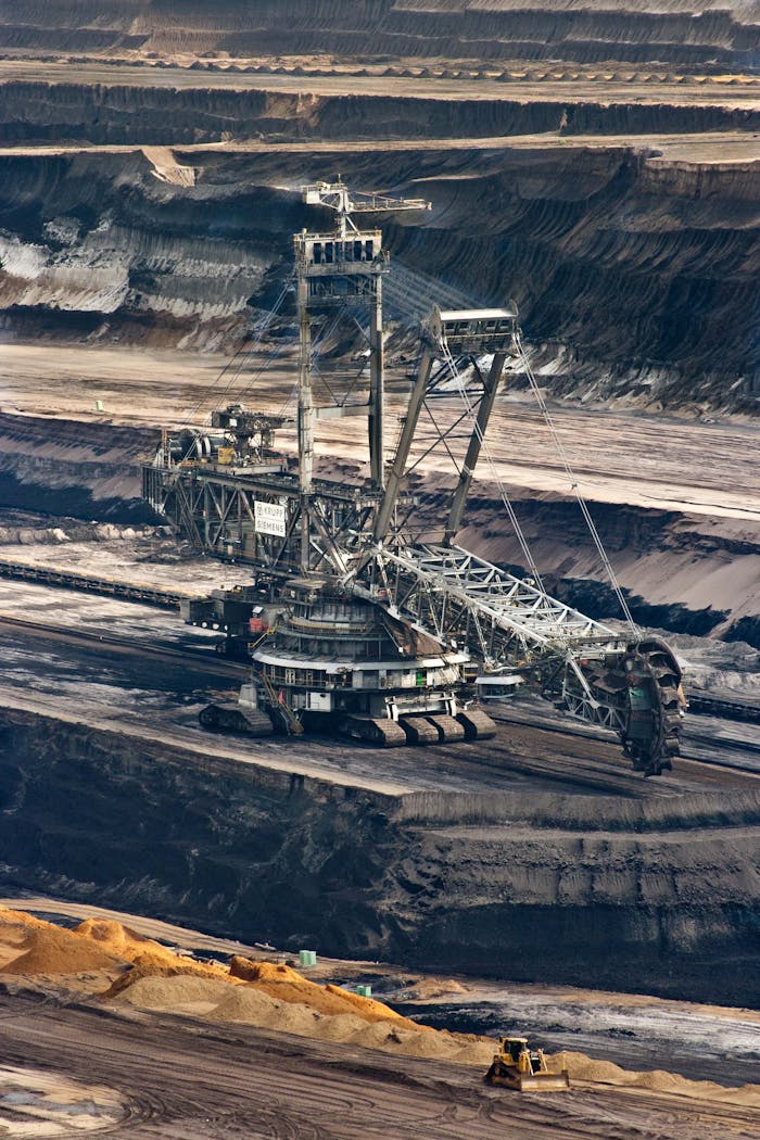 about-01 Large bucket wheel excavator operating in an open-pit mine with layered soil and coal.