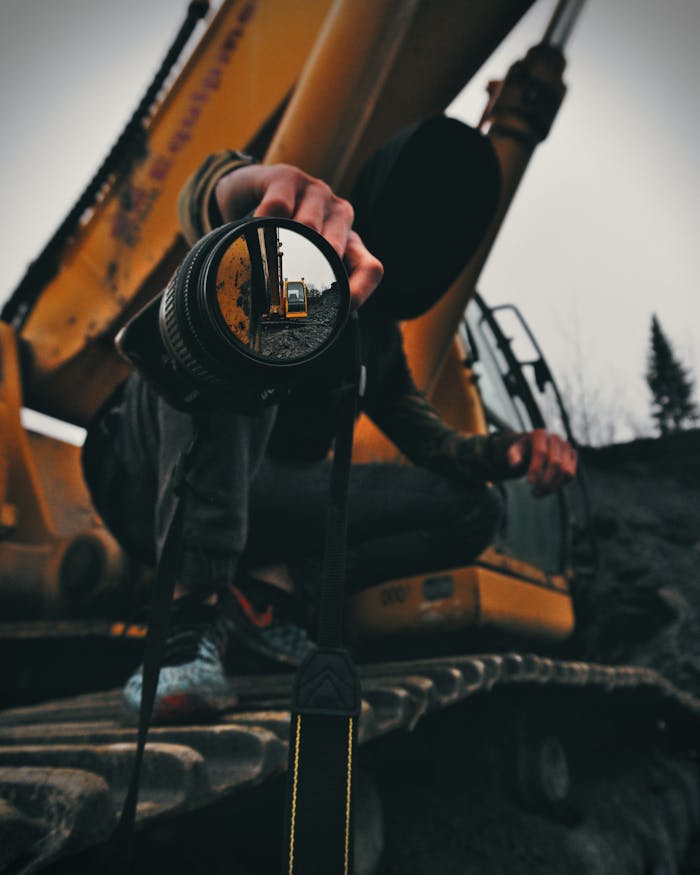 A unique perspective of an excavator captured through a camera lens reflection outdoor.