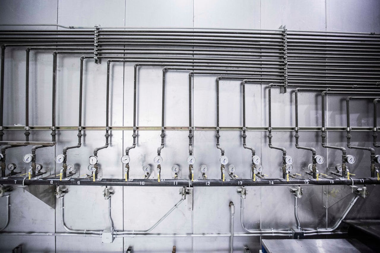 services-03 Detailed view of an industrial plumbing system featuring multiple pressure gauges and steel pipes.
